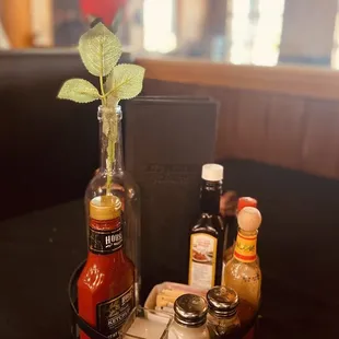 a table with a bottle of sauce and a bottle of hot sauce
