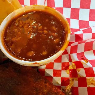 a plate of ribs and a side of beans