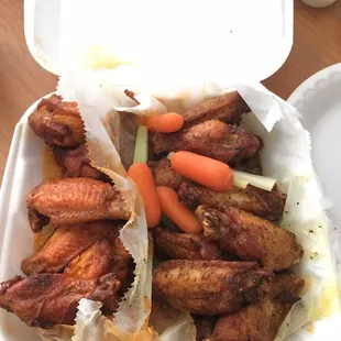 chicken wings and carrots in a styrofoam container