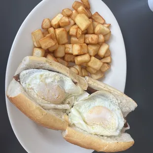 Bacon, sausage, eggs over easy &amp; cheese on Italian roll with home fries