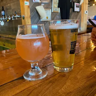 two glasses of beer on a bar