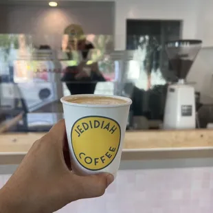 a hand holding a cup of coffee