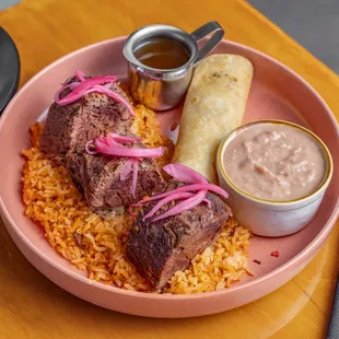 Birria Rib platter, braised beef atop spanish rice