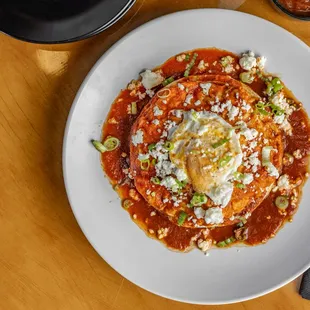 A classic enchilada with queso fresco, green onions layered betwen