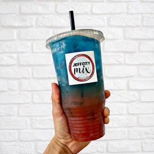 a hand holding a drink