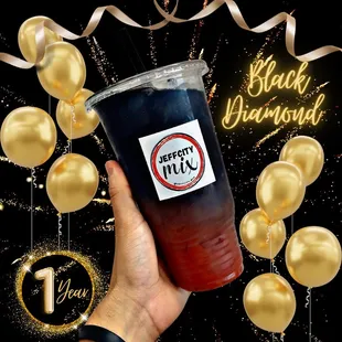 a hand holding a cup of black diamond