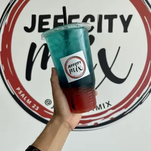 a hand holding a drink