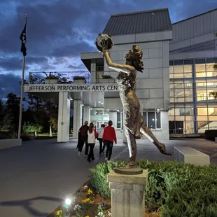 a statue of a woman holding a baseball glove