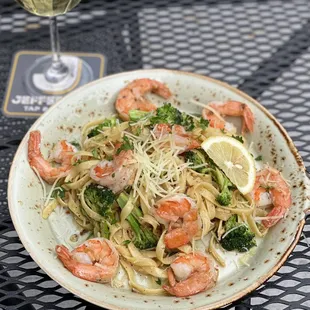 a plate of pasta with shrimp and broccoli