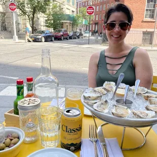 a woman sitting at a table with oysters