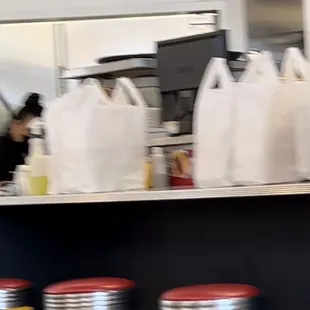 Dozen huge bags food being filled for only take out while ignore dozen customers at table