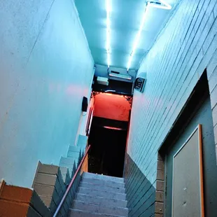 a stairway leading to a neon sign