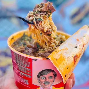 a hand holding a bowl of jefitaz