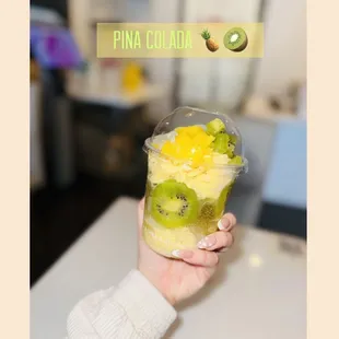 a person holding a cup of fruit