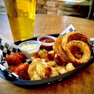 a tray of food and a glass of beer