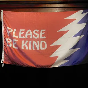 a red, white, and blue banner with the words please be kind