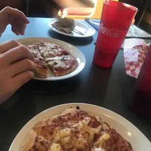 a person taking a slice of pizza