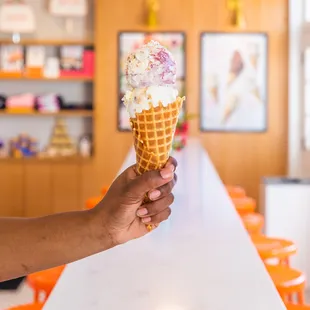 a hand holding an ice cream cone