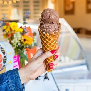 a hand holding a waffle cone