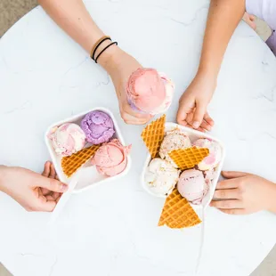 three people holding ice cream cones