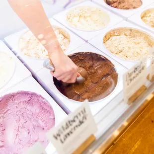 a woman's hand reaching for a scoop of ice cream