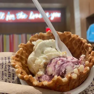 a hand holding a waffle with a spoon