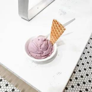 a bowl of ice cream with a waffle cone sticking out of it