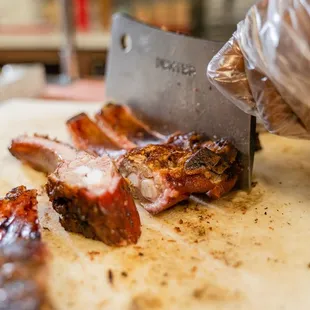 a person cutting meat on a cutting board