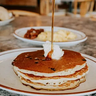 a pancake being drizzled with syrup