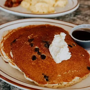 a plate of pancakes with butter and syrup