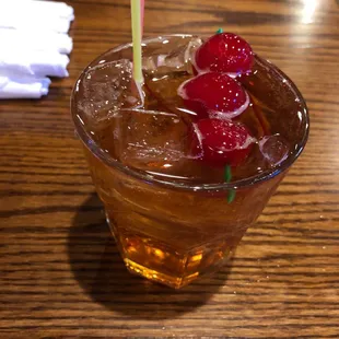 a glass of iced tea with raspberries