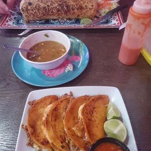 Large burrito and quesabirria tacos. Limes for scale.