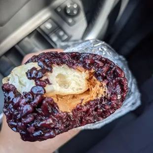 a hand holding a half eaten donut