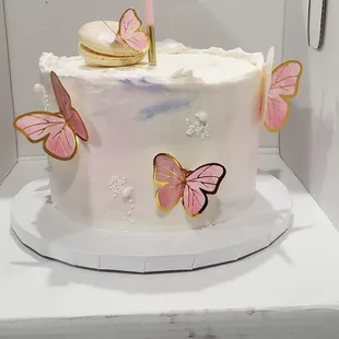 a white cake with pink butterflies