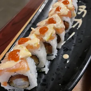 a close up of a sushi roll on a black plate