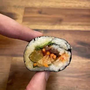 shows a hand holding a sushi