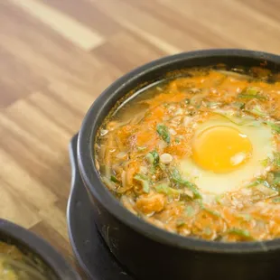 a bowl of soup with an egg on top