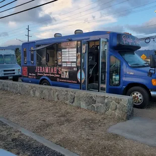 a blue food truck parked on the side of the road