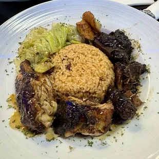 Jerk Chicken &amp; Oxtail plate with rice &amp; peas, cabbage, and plantain.