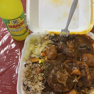 a plastic container with rice, meat, and vegetables