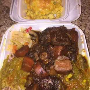 Rice and peas with oxtails and curry goat gravy with a side of mac and cheese