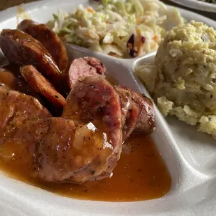 Smoked sausage in sauce with potato salad &amp; Cole slaw