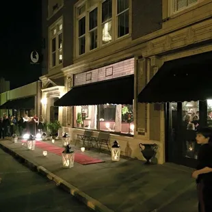 people walking down the sidewalk at night