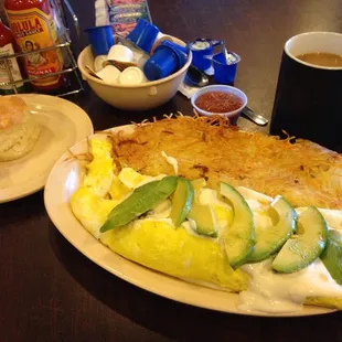 The Chorizo Omlette. Stuffed with a ton of chorizo and topped with avocado and white queso sauce. $10 w/ hashbrowns &amp; a biscuit.