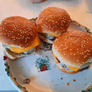 three cheeseburgers on a plate