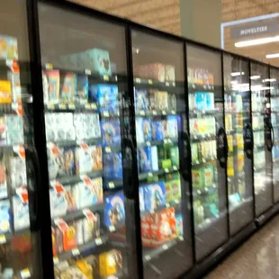 a grocery store aisle with refrigerators