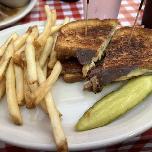 Chicken breast with bacon on rye bread with French fries and dill pickle