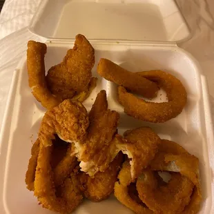fried onion rings in a styrofoam container