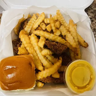 a burger and fries in a styrofoam container