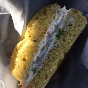 Half of spinach quiche bagel with veg cream cheese